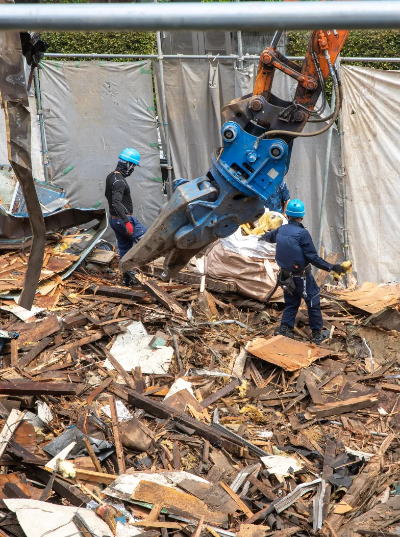 Demolition workers with heavy machinery and debris removal in Dallas TX