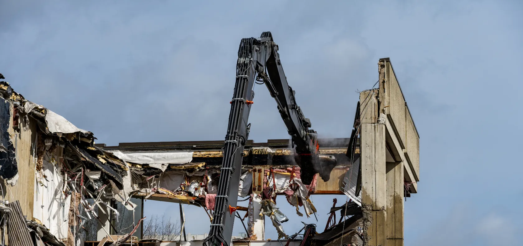 Commercial demolition in Dallas TX tearing down large building using heavy equipment and structural removal process