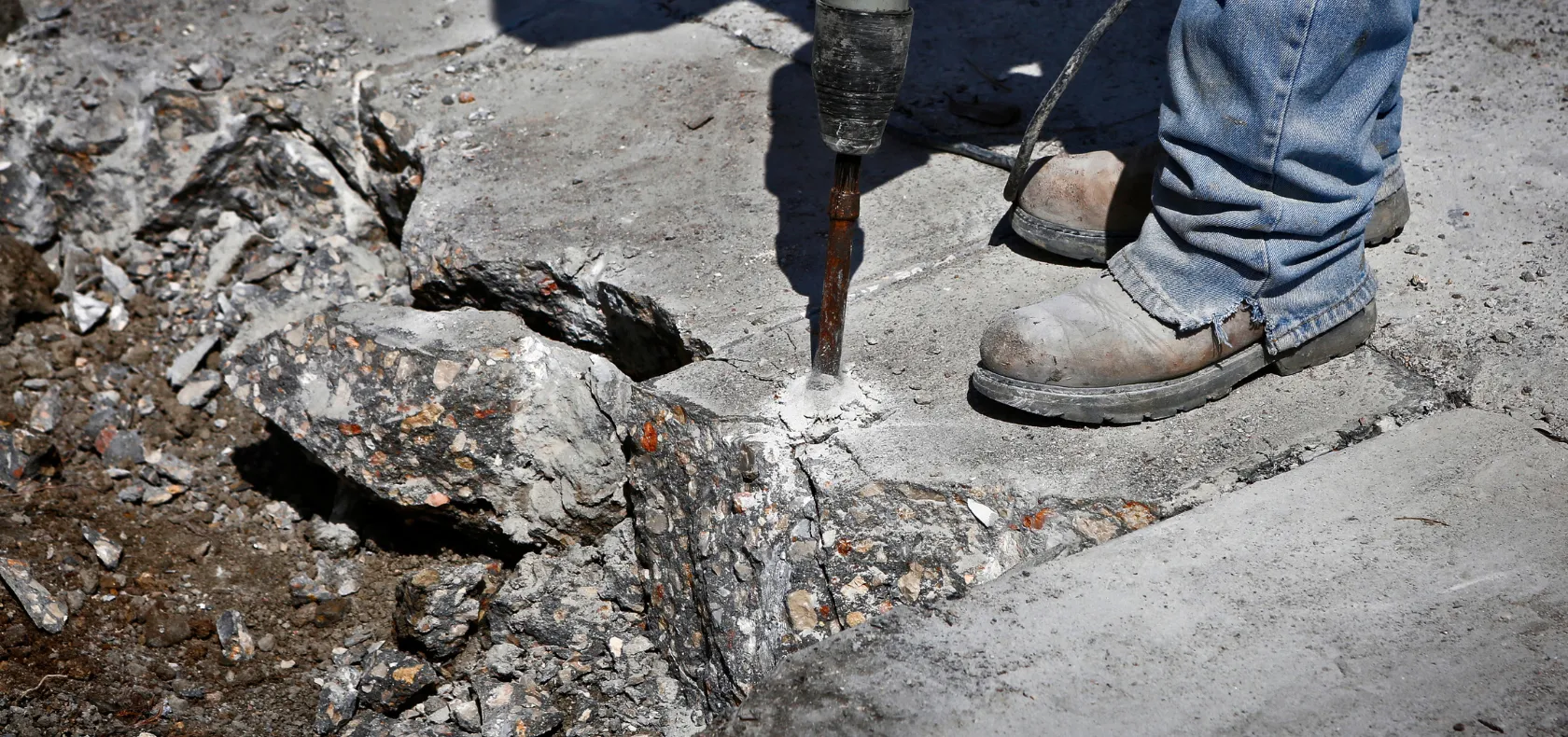 Concrete removal in Dallas TX showing jackhammer breaking concrete slab
