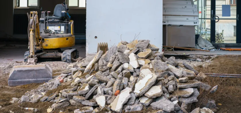 Commercial demolition in Dallas TX with large debris piles and interior structural removal in progress