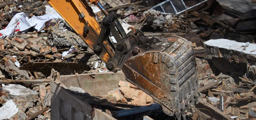 Commercial demolition in Dallas TX with excavator removing debris and clearing construction site