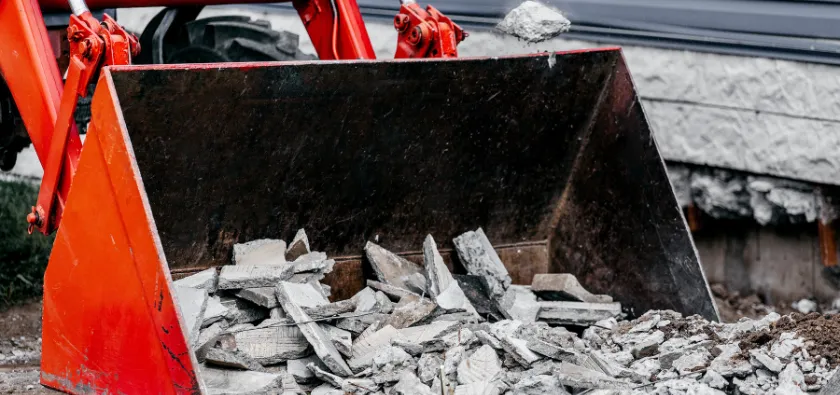 Concrete removal in Dallas TX showing broken concrete debris being loaded into equipment for disposal